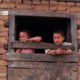 Siblings in the Window, by Shikchit Khanal - Candid Photography, Award Winning Photography, Photojournalism, Photography Education, Art Photography