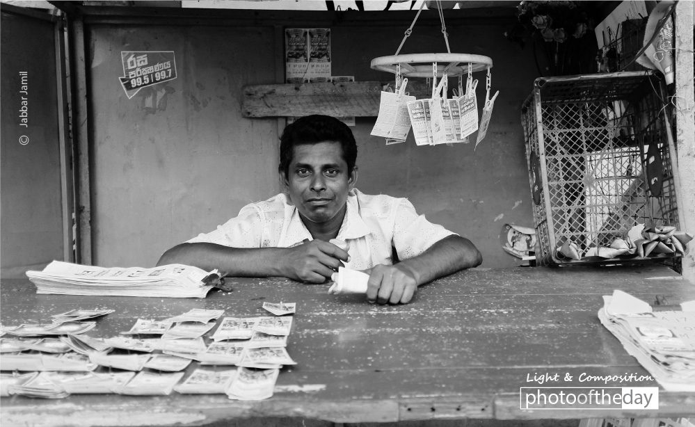 The Lottery Ticket Seller, by Jabbar Jamil The Lottery Ticket Seller, by Jabbar Jamil - Street Photography, Photojournalism, Portrait Photography, Photo of the Day, Photography Awards