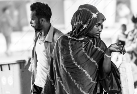 A Woman in a Patterned Headscarf and a Man in Profile