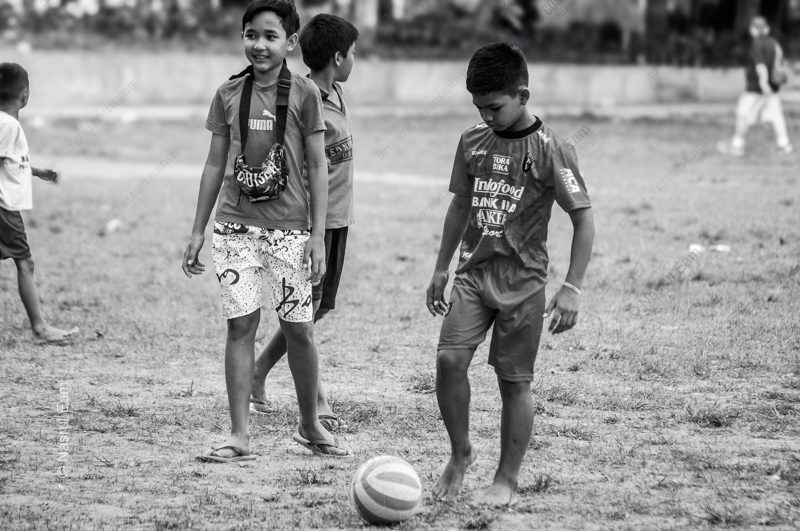 Boys with a Soccer Ball on a Worn Field Boys with a Soccer Ball on a Worn Field - Fine Art Photography Print, Limited Edition Photography, Monochrome Photography, Childhood Photography, Art Photography for Sale