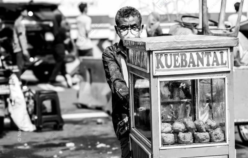 The Kue Bantal Vendor The Kue Bantal Vendor - Fine Art Photography Print, Limited Edition Photography, Documentary Photography, Black and White Photography, Art Photography for Sale