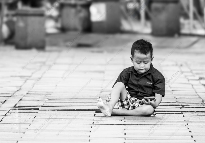 A Boy and His Phone on a Wooden Floor