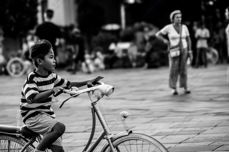 Young Boy on a Bicycle in a Paved Square Nasrul Eam