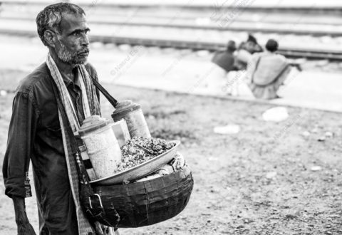 Vendor by the Railway Tracks - documentary portraiture, photography technique tutorials, visual storytelling photography, human emotion in photography, street photography guide
