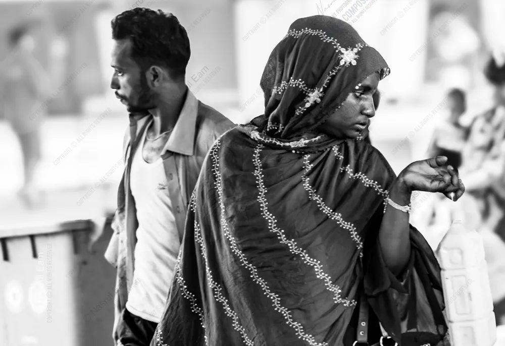 A Woman in a Patterned Headscarf and a Man in Profile