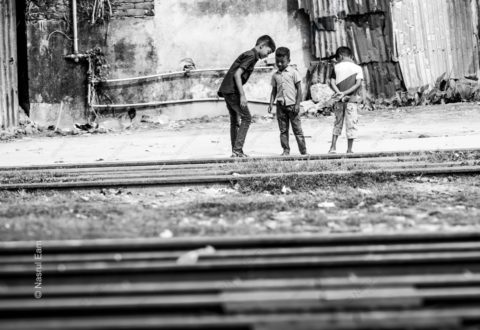 Three Boys Standing by the Railway Tracks