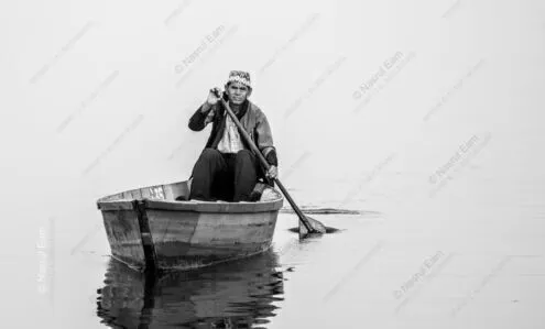 The Boatman's Gaze on Misty Waters