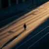 A lone figure crossing a wide city street at golden hour — visual storytelling through composition and the frame