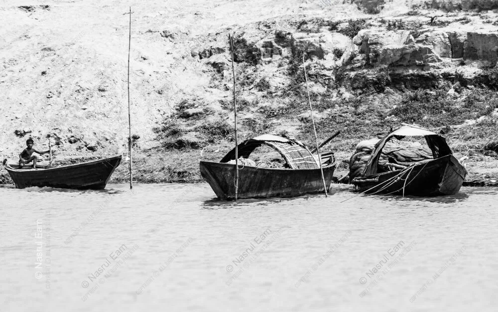 Three Wooden Crafts Along the Sunlit Bank