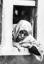 Woman in Patterned Headscarf Leaning Outward - Woman in Patterned Headscarf Leaning Outward, woman in patterned headscarf, fine art photography, monochrome candid portrait, limited edition prints, Nasrul Eam