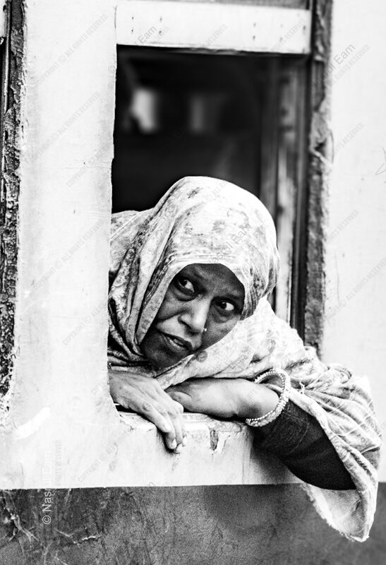 Woman in Patterned Headscarf Leaning Outward - Woman in Patterned Headscarf Leaning Outward, woman in patterned headscarf, fine art photography, monochrome candid portrait, limited edition prints, Nasrul Eam