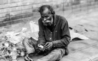 Man Unwrapping Sustenance by the Brick Wall - Man Unwrapping Sustenance by the Brick Wall, fine art street photography, Nasrul Eam fine art print, monochrome art print, limited edition photography print, buy street photography print
