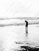 Figure Bent Over the Incoming Tide - Figure Bent Over the Incoming Tide, solitary figure incoming tide, monochrome seascape art, Nasrul Eam fine art print, Limited Edition Prints, Black and White Photography