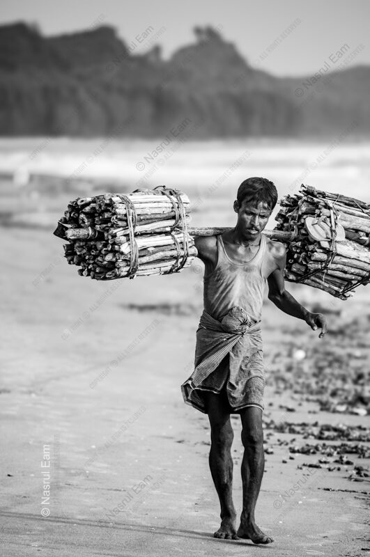 Wood Carrier on the Shoreline - Wood Carrier on the Shoreline, Nasrul Eam fine art print, limited edition black and white photo, monochrome documentary photography, buy fine
