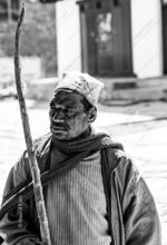 Man with Curving Wooden Staff and Patterned Cap - Man with Curving Wooden Staff, limited edition fine art print, monochrome portrait photography, Nasrul Eam photography, documentary portraiture, buy fine art prints