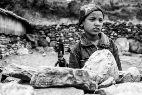 Boy in Knit Cap Behind Stacked Stones