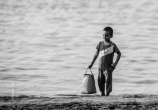 Boy with Woven Basket at Water's Edge - Boy with Woven Basket, boy water's edge, Nasrul Eam photography, black and white fine art print, limited edition prints, artistic portraits