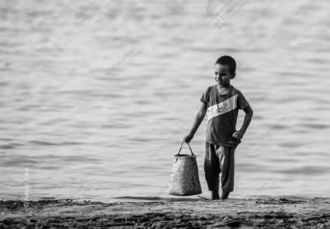 Boy with Woven Basket at Water's Edge