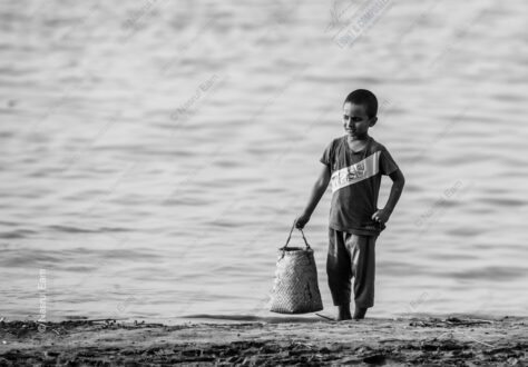 Boy with Woven Basket at Water's Edge