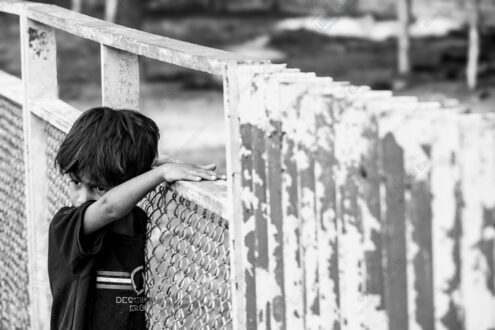 Child's Hand on Weathered Rail