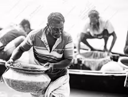 Man Lifting Pot of Catch