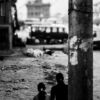 Figures in a Divided Alleyway - street photography, documentary photography, visual storytelling, photography composition, urban photography, black and white photography