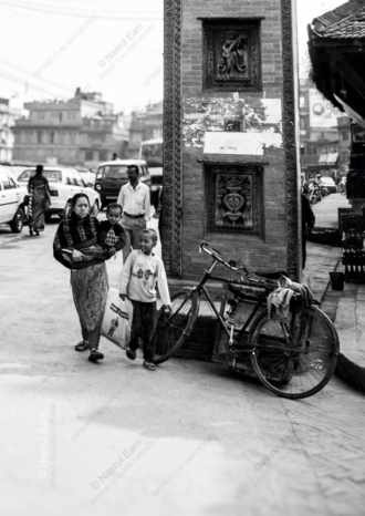 A Family's Passage by the City Pillar