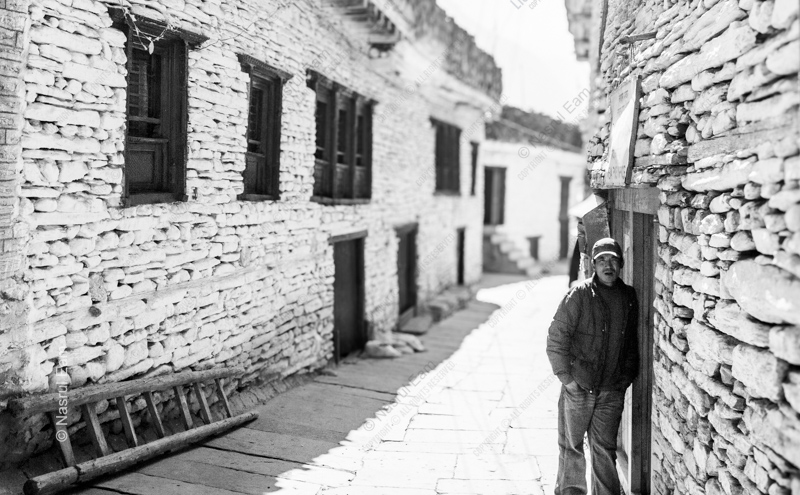 A Man in a Sunlit Stone Alley
