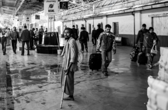 A Man with a Crutch on a Crowded Platform