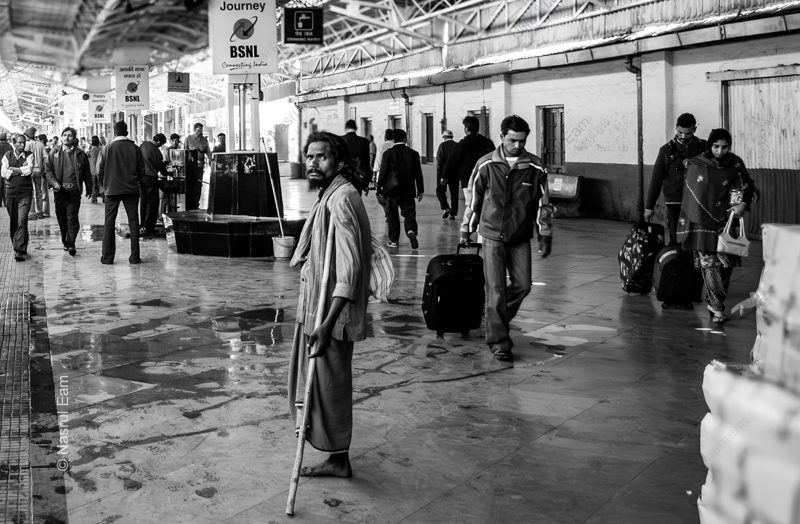 A Man with a Crutch on a Crowded Platform