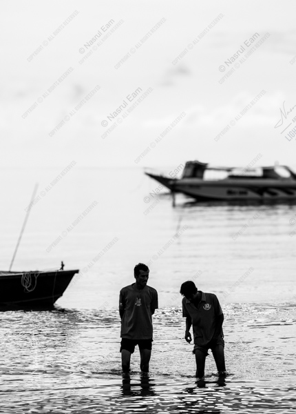 Two Men Wading by the Shore