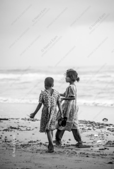 Two Young Girls Walking along a Beach
