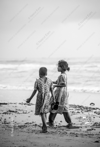 Two Young Girls Walking along a Beach