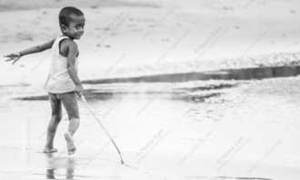 Boy with Stick at Water's Edge