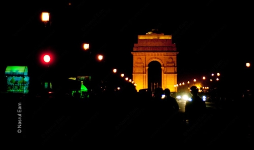 Figures Before the Golden Arch at Night