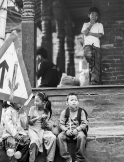 Children Waiting by a Brick Wall