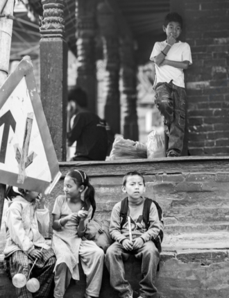 Children Waiting by a Brick Wall