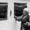 An Elder with Mala Beads by a Whitewashed Wall