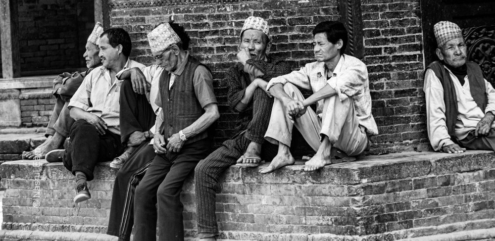 Men Seated Along the Brick Wall