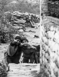 Two Children Sharing a Moment on a Mountain Path