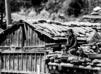 Girl Seated on a Rooftop of Stone and Wood