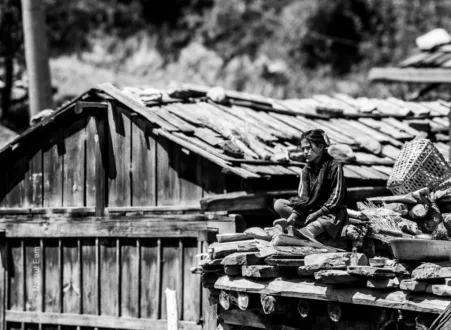 Girl Seated on a Rooftop of Stone and Wood