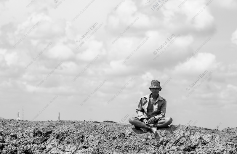 Man Seated on an Earthen Mound