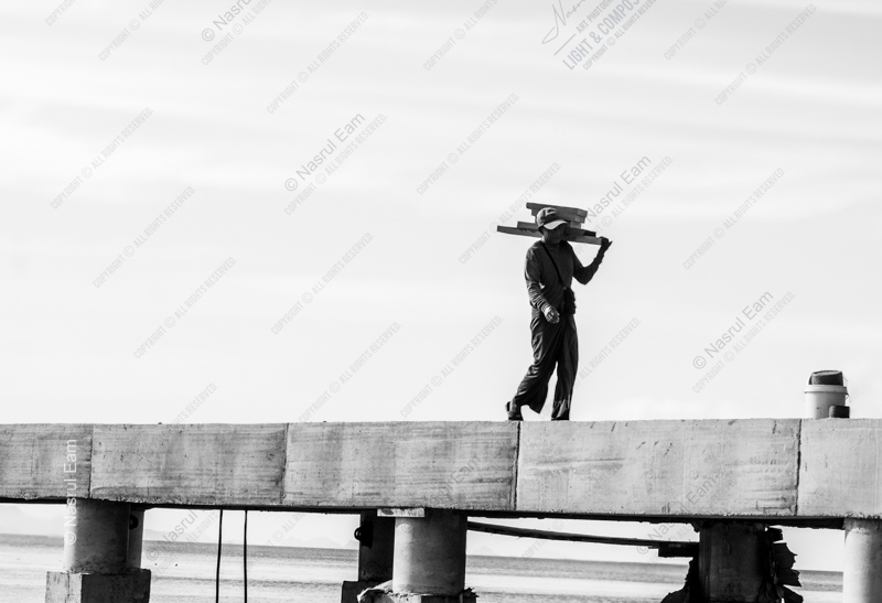 The Solitary Worker on the Pier