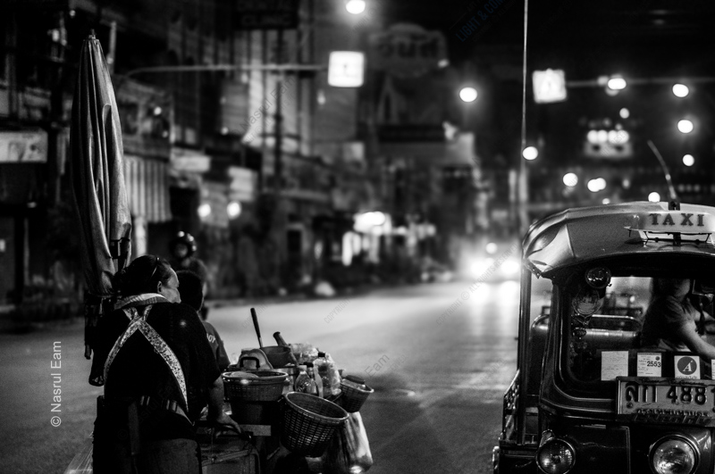 A Vendor and a Tuk-Tuk at Night
