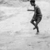 A Boy Tossing a Stone on a Dusty Plain - Fine Art Photography Print, Limited Edition Photography, Museum-Quality Photography, Contemporary Art Photography, Photography for Collectors