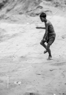 A Boy Tossing a Stone on a Dusty Plain - Fine Art Photography Print, Limited Edition Photography, Museum-Quality Photography, Contemporary Art Photography, Photography for Collectors