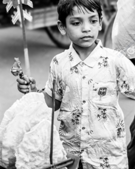 Boy with Pinwheel and Jhal Muri - Fine Art Photography Print, Limited Edition Print, Monochrome Photography,  Art Photography,  Contemporary Photography