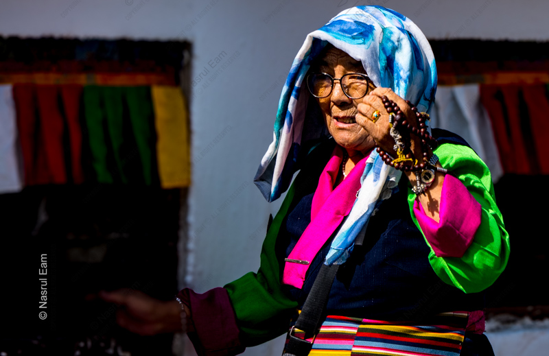 Elder with Prayer Beads in Sunlight