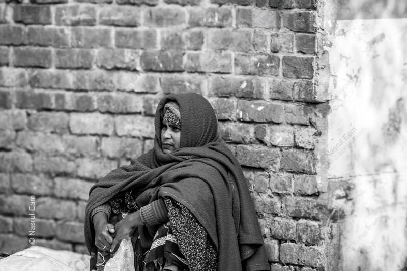Woman Seated by a Brick Wall